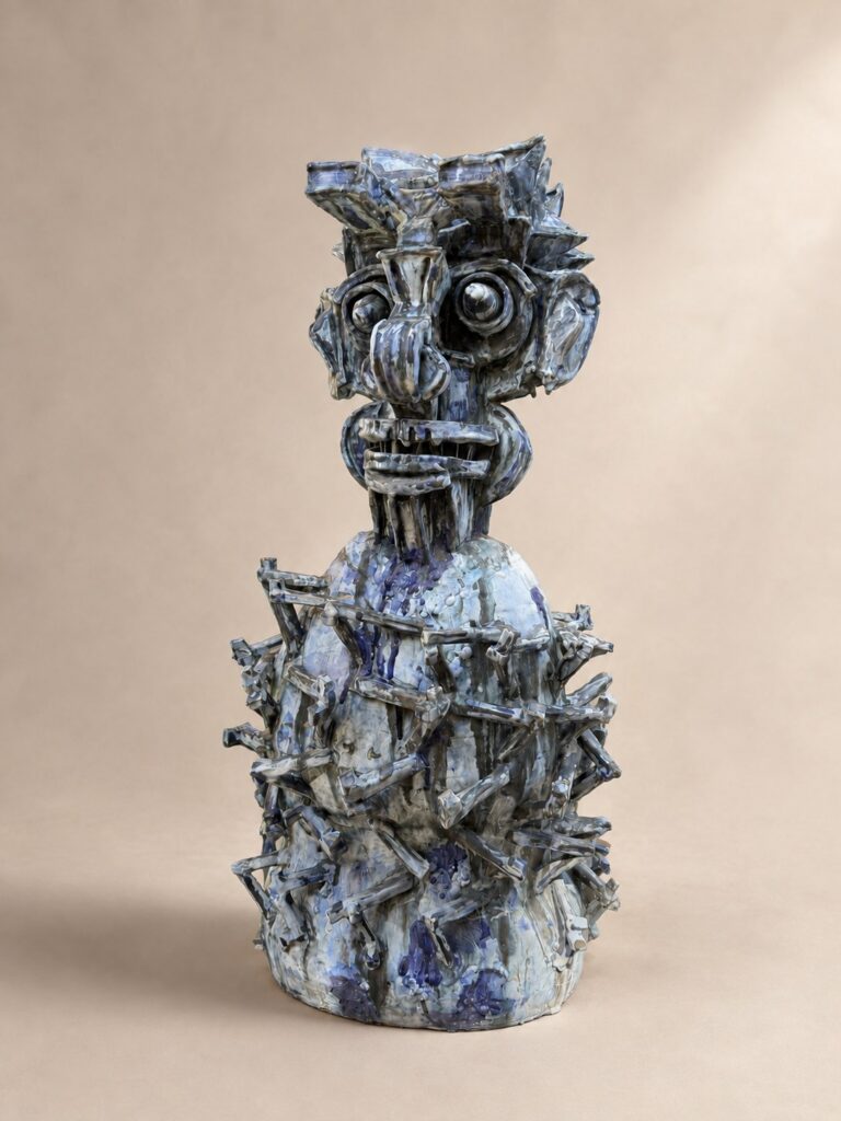 Blue totem figure with spiked layers. Ceramic sculpture by Ted Fullwood