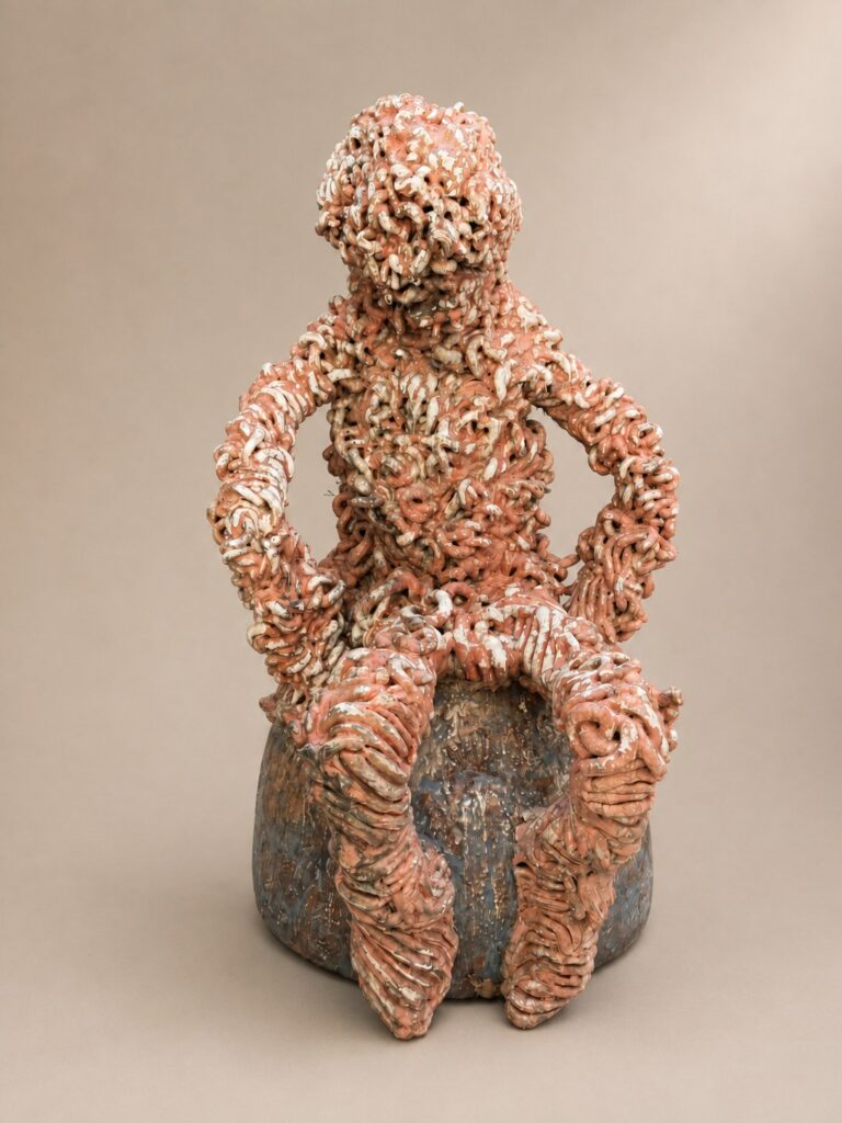 Seated figure in textured terracotta. Ceramic sculpture by Ted Fullwood