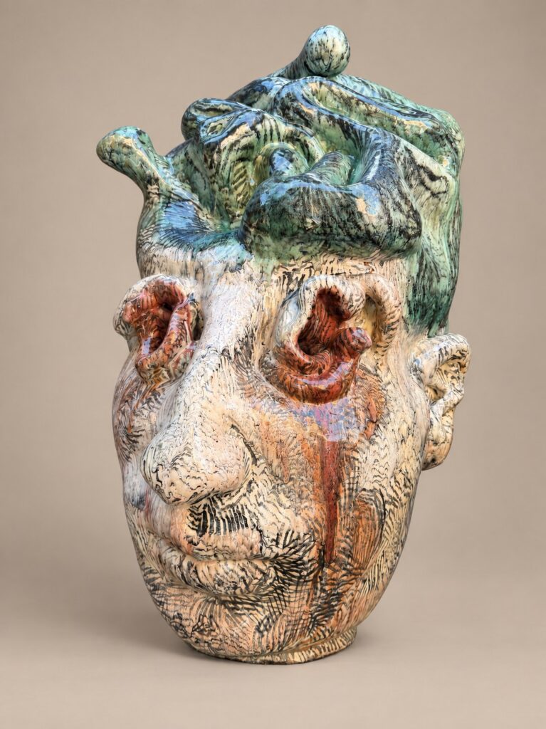 Head with a green-glazed crown. Ceramic sculpture by Ted Fullwood